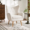 Poltrona club wingback trapuntata in bouclé con gambe in legno di hevea