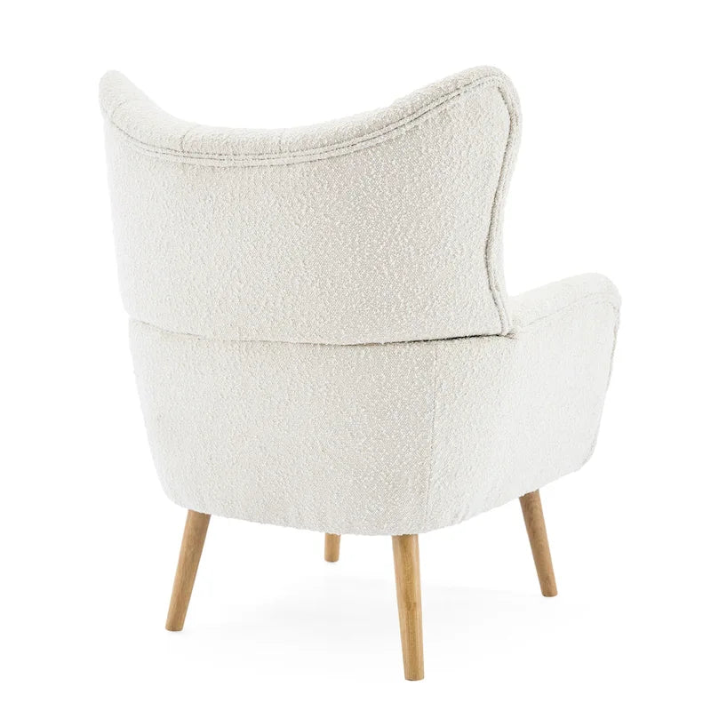 Poltrona club wingback trapuntata in bouclé con gambe in legno di hevea