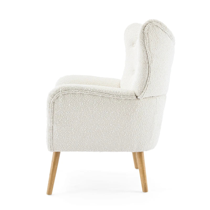 Poltrona club wingback trapuntata in bouclé con gambe in legno di hevea