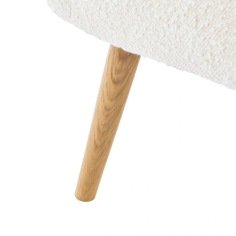 Poltrona club wingback trapuntata in bouclé con gambe in legno di hevea