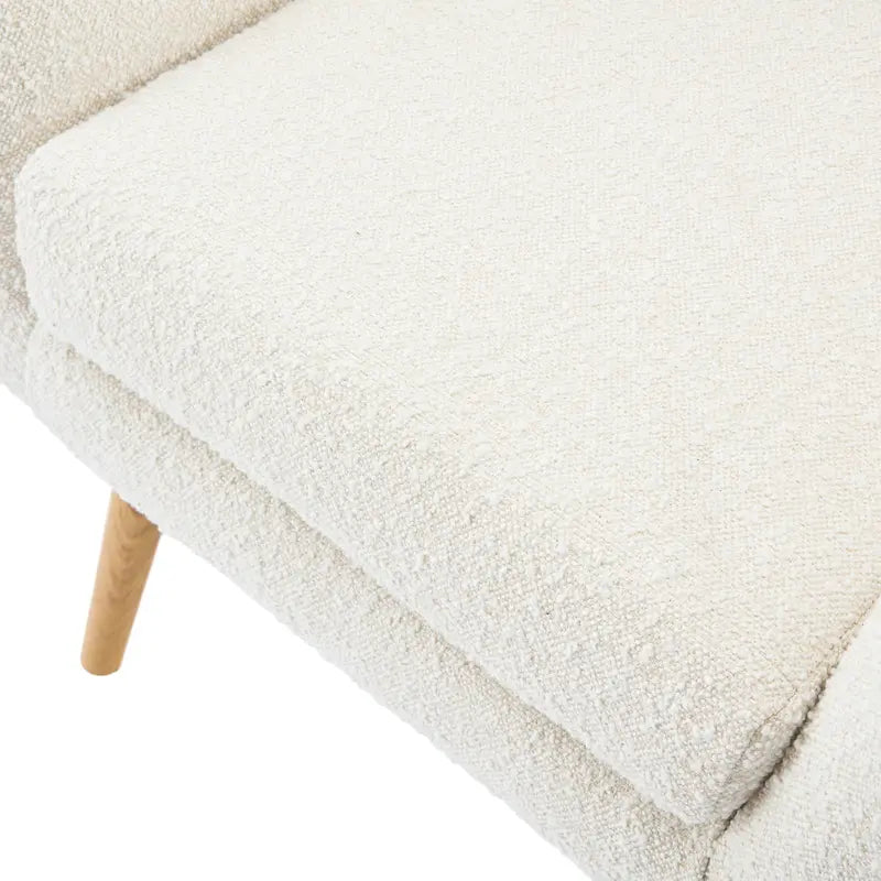 Poltrona club wingback trapuntata in bouclé con gambe in legno di hevea